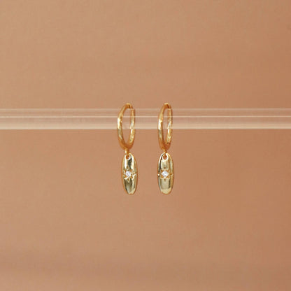 Vue de face des boucles Elavyo dorées – pendentif ovale étoilé avec zircon