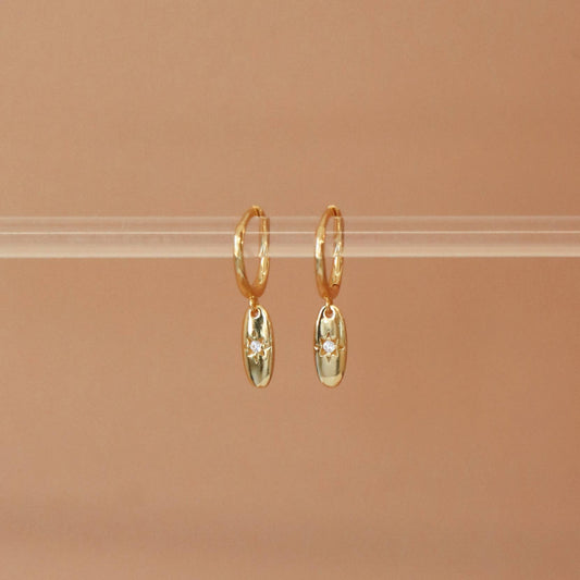 Vue de face des boucles Elavyo dorées – pendentif ovale étoilé avec zircon