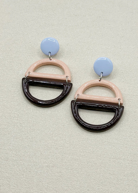 Boucles d’oreilles graphiques en argile polymère bleu pâle, rose et chocolat, vue studio