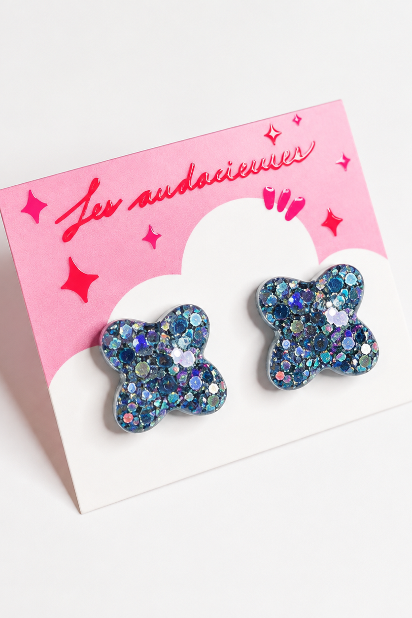 Boucles d’oreilles clou Les Audacieuses Confettis bleu, coulées à la main en résine époxy avec détails pailletés.