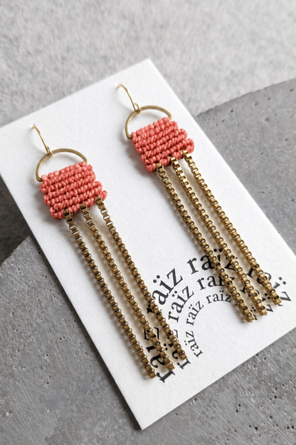 Boucles d’oreilles corail et dorées présentées sur carton, avec chaînes pendantes et style bohème chic.
