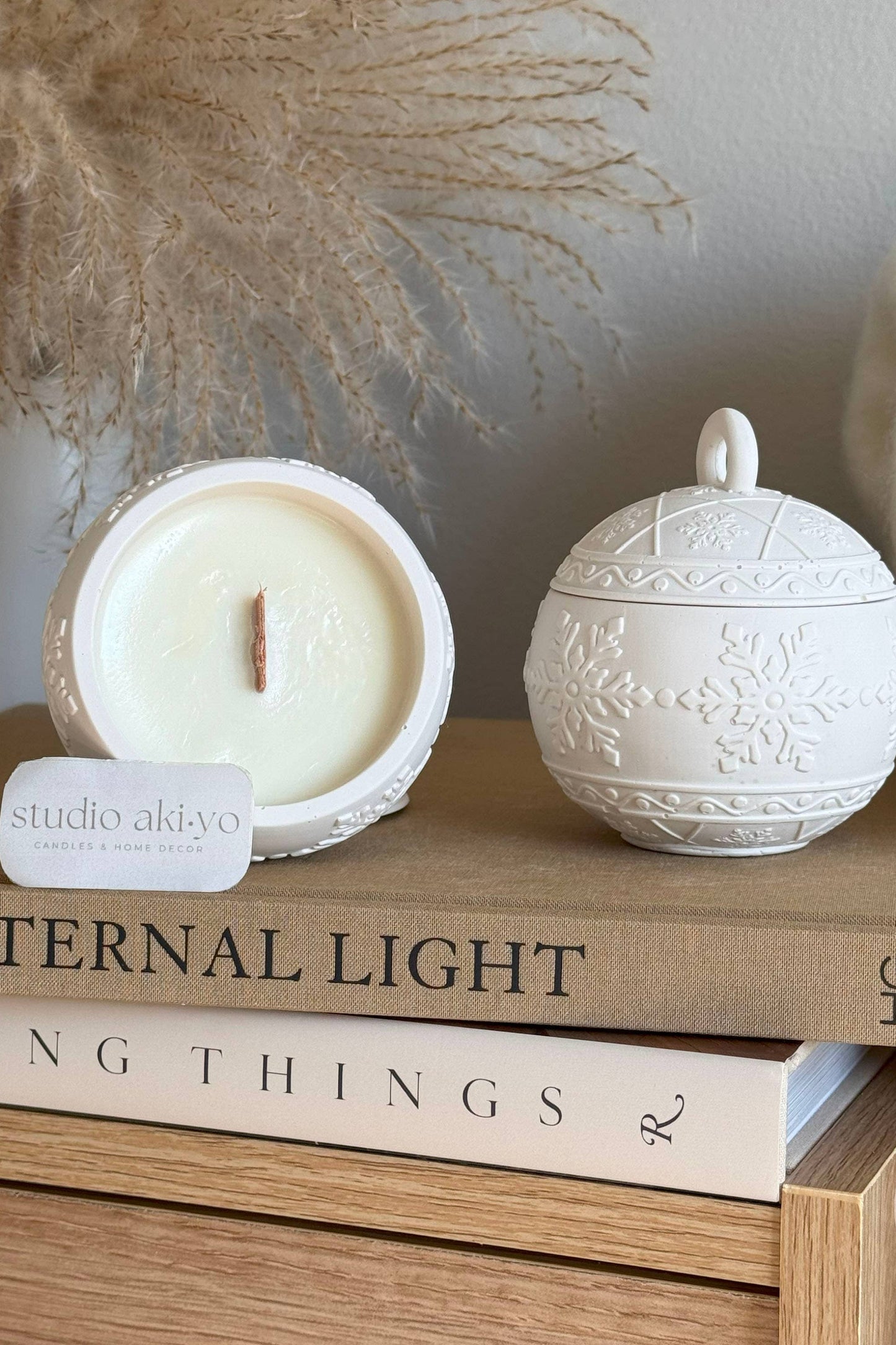 Bougie artisanale parfumée Winterberry, pot en forme de boule de Noël blanche, mèche en bois et cire de soja.