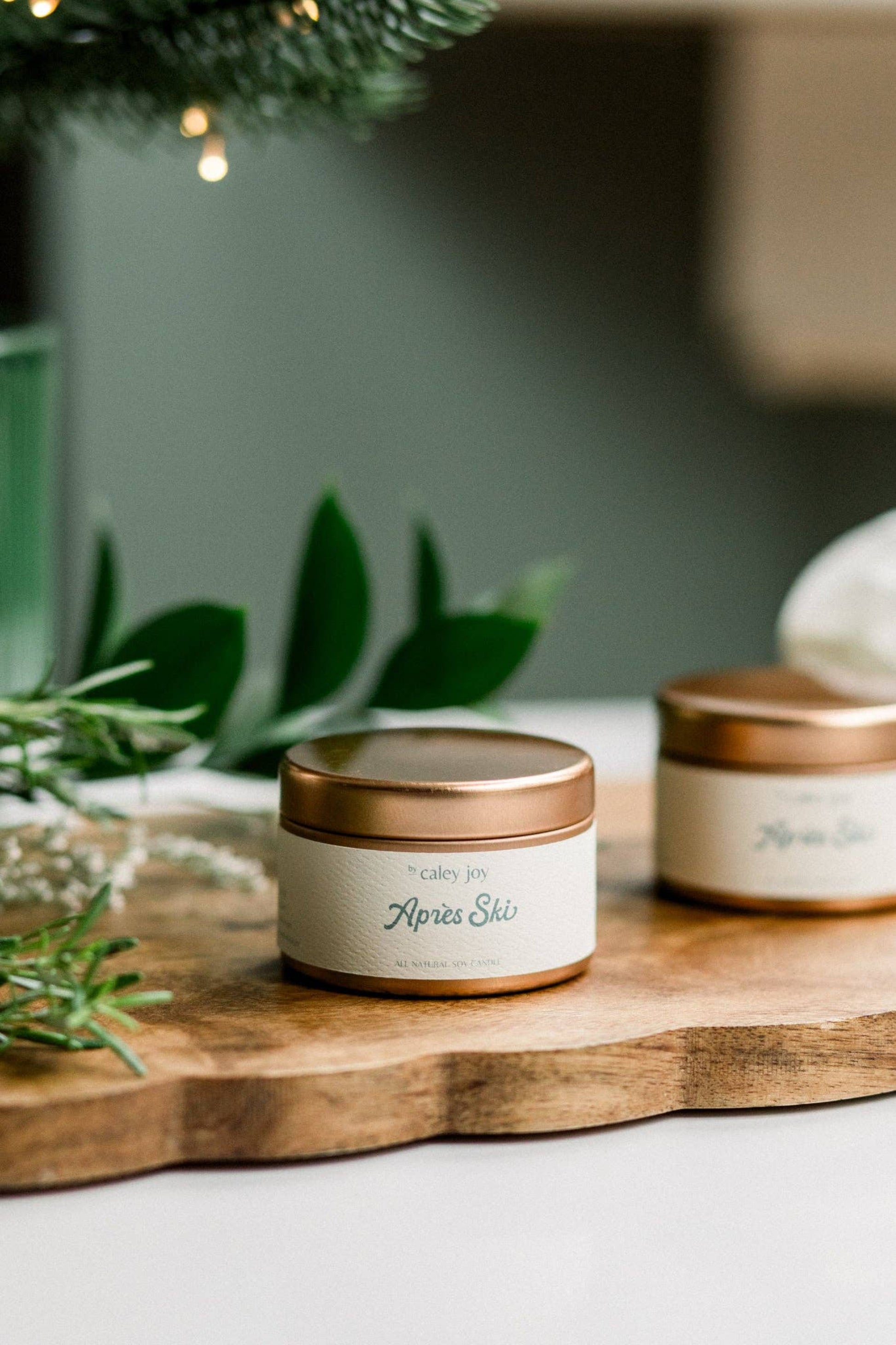 Bougie Après Ski en cire de soja posée avec feuillage vert • Parfum menthe poivrée et vanille