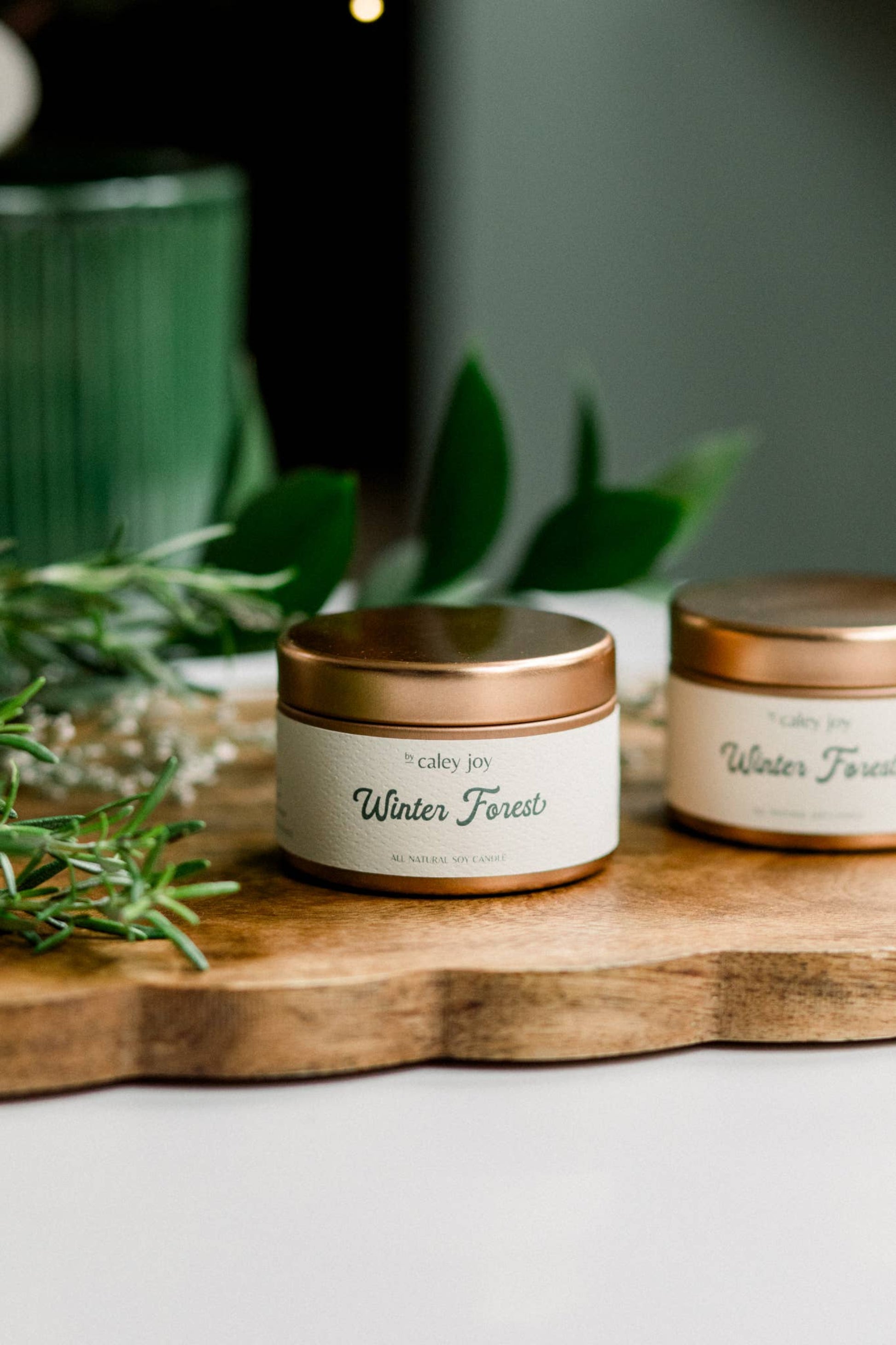 Gros plan sur la bougie Forêt d’Hiver et son étiquette crème • Mèche en coton et finition dorée