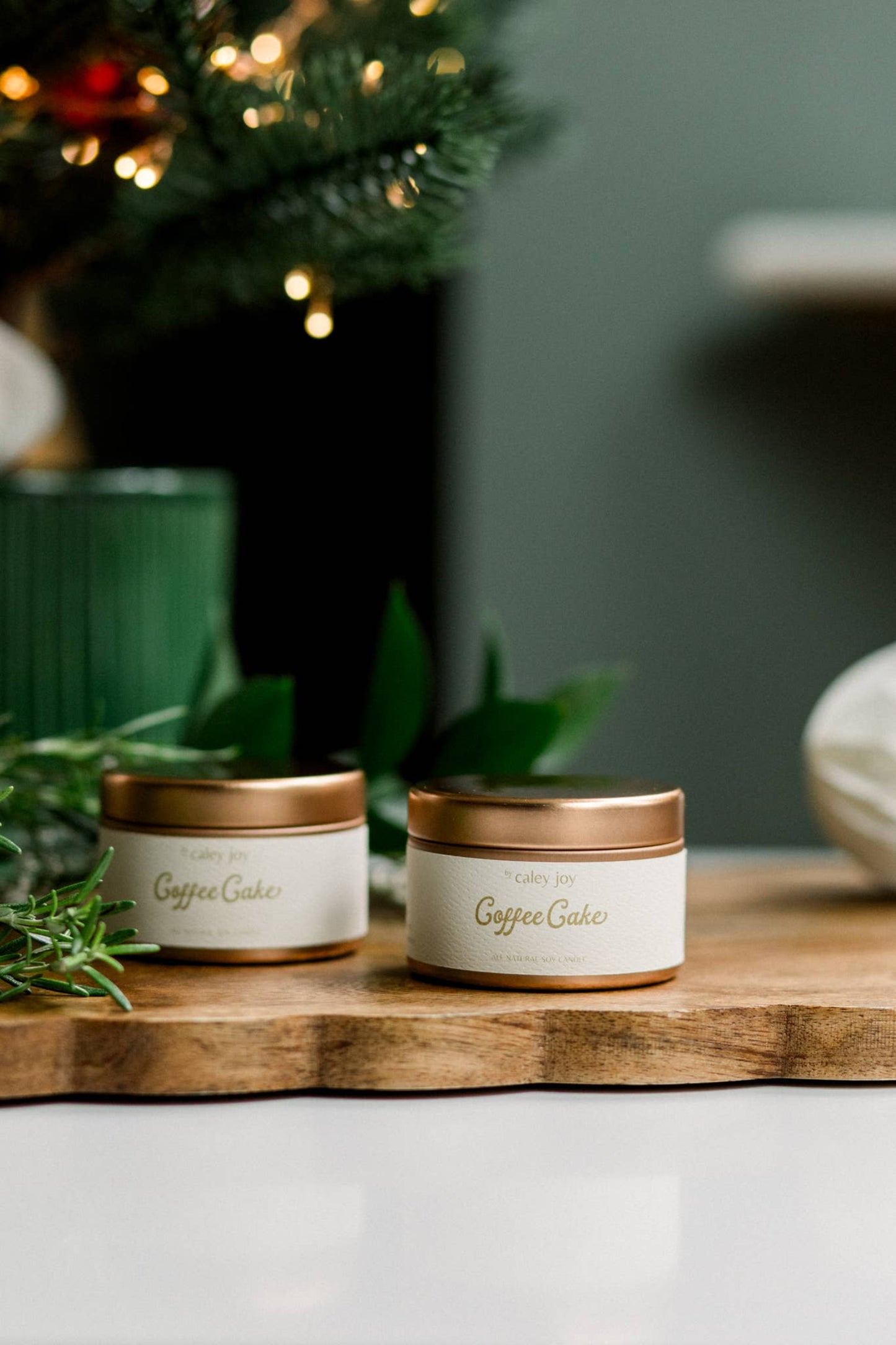 Bougie gâteau au café en cire de soja naturelle posée sur une planche de bois avec feuillage, ambiance chaleureuse.