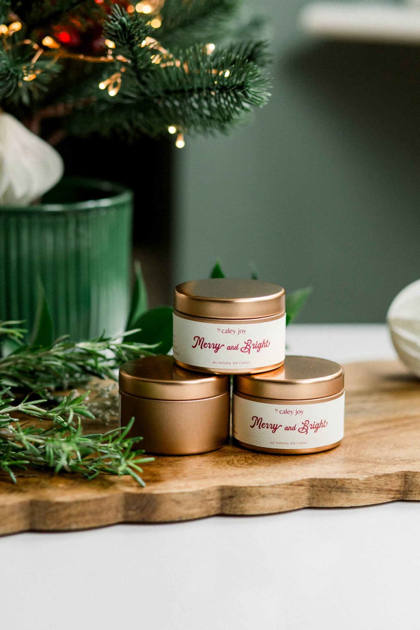 Détail du pot doré et de l’étiquette crème de la bougie Joyeux & Éclatant • Profil olfactif cassis et feuillage vert