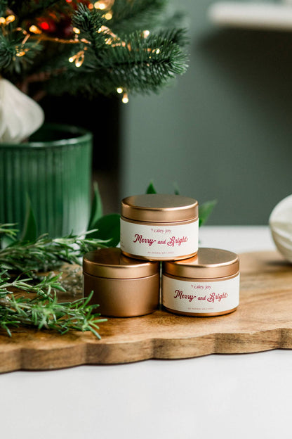 Détail du pot doré et de l’étiquette crème de la bougie Joyeux & Éclatant • Profil olfactif cassis et feuillage vert