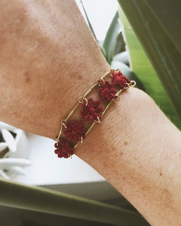 Bracelet Amalfi avec fleurs brodées rouges sur chaîne dorée, vue porté au poignet