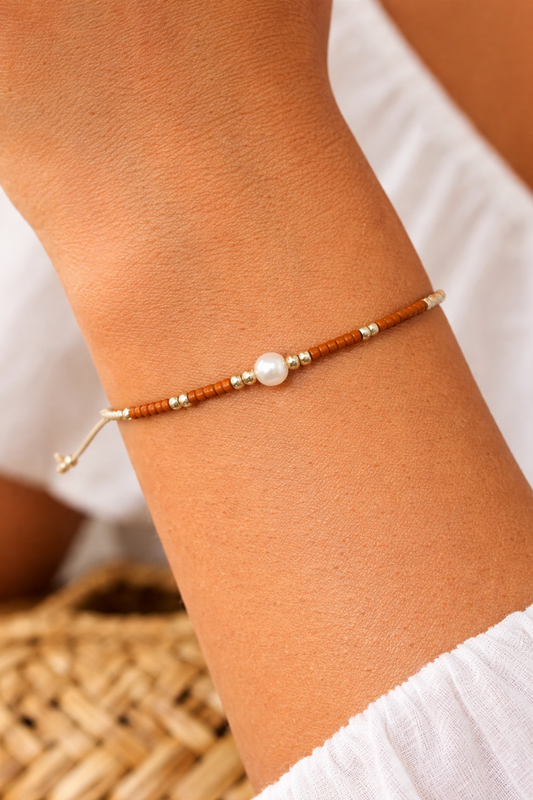 bracelet minimaliste porté au poignet avec perle centrale élégante