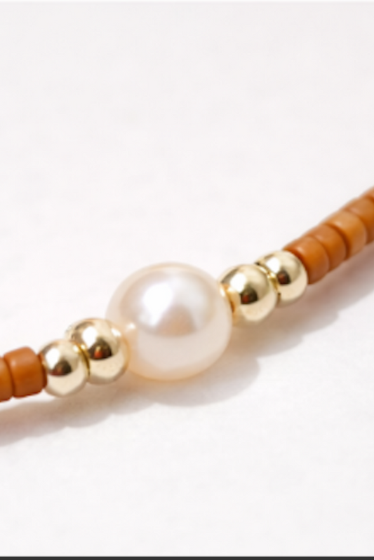 détail zoom sur perle centrale et perles dorées bracelet fin