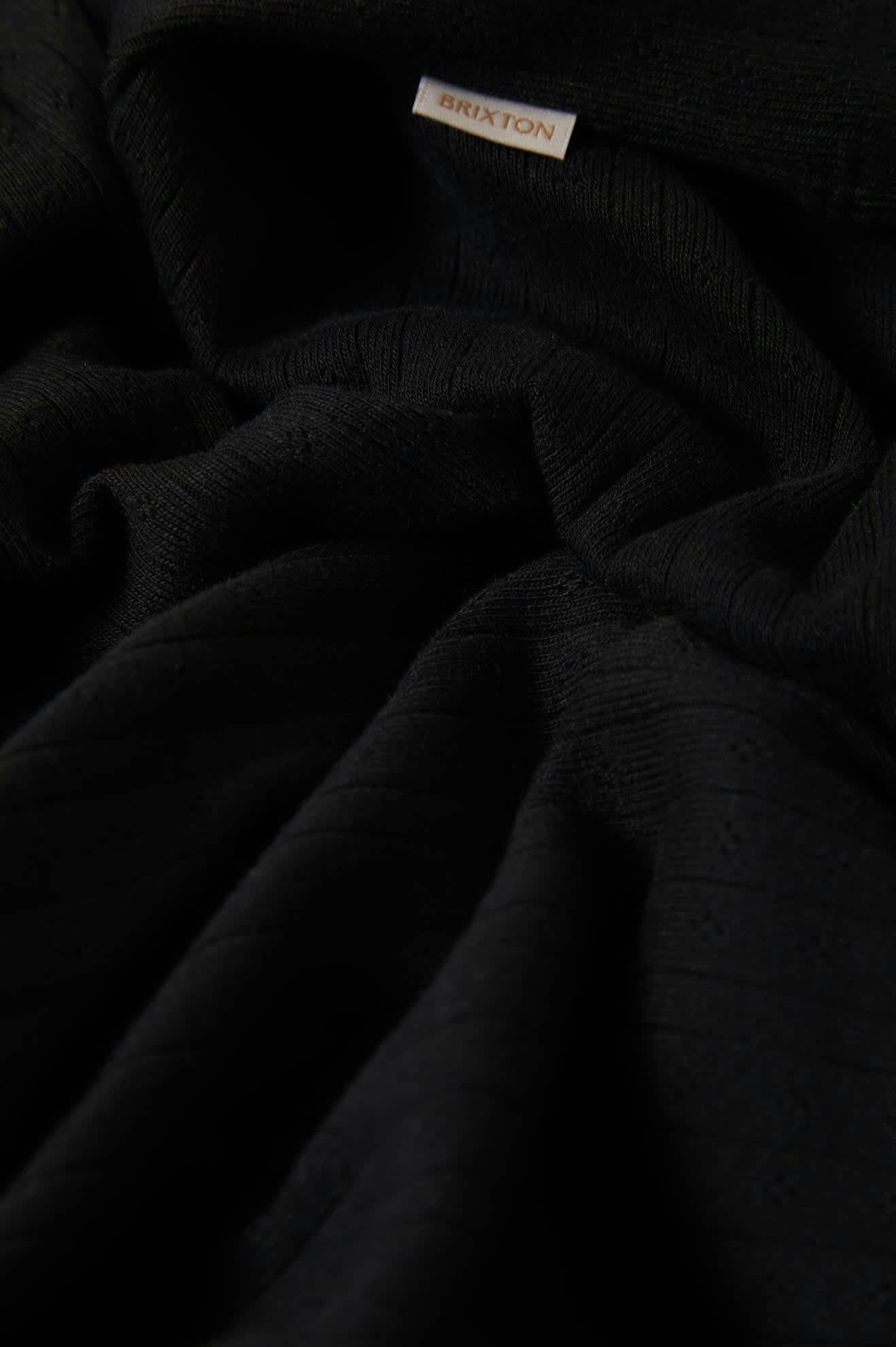 Gros plan sur le tissu pointelle noir Brixton – motif ajouré discret