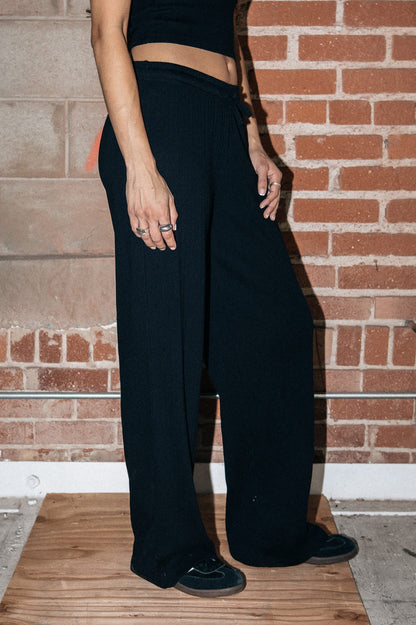 Tenue urbaine avec pantalon pointelle noir Brixton et baskets noires.