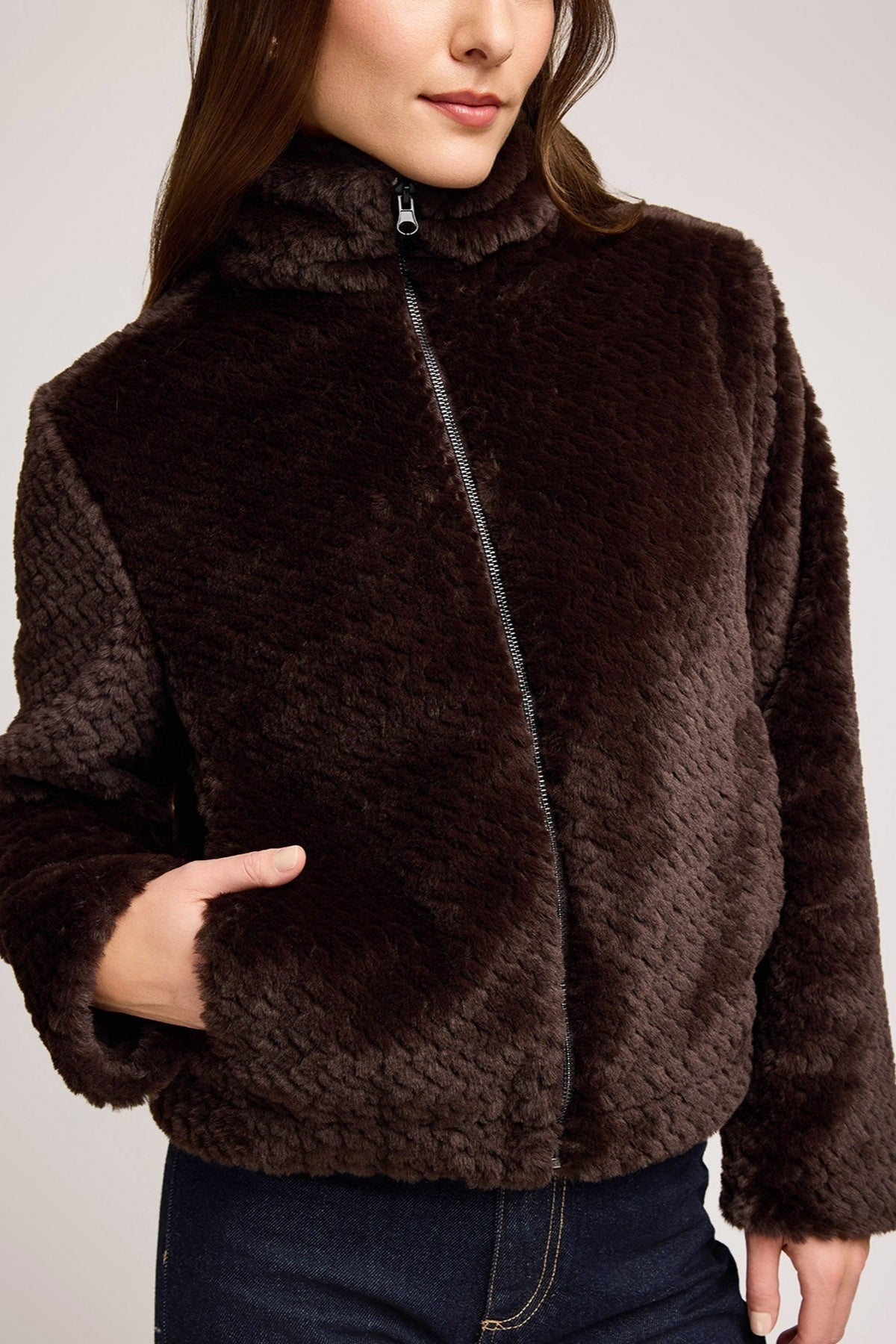 Gros plan sur la fermeture zippée et la texture fausse fourrure de la veste java