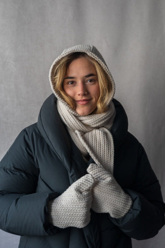 Capuche foulard beige en tricot souple portée sur la tête avec manteau noir