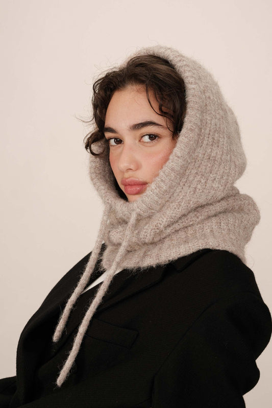 Modèle portant la capuche Roma taupe – look chaleureux, maille douce et protectrice.