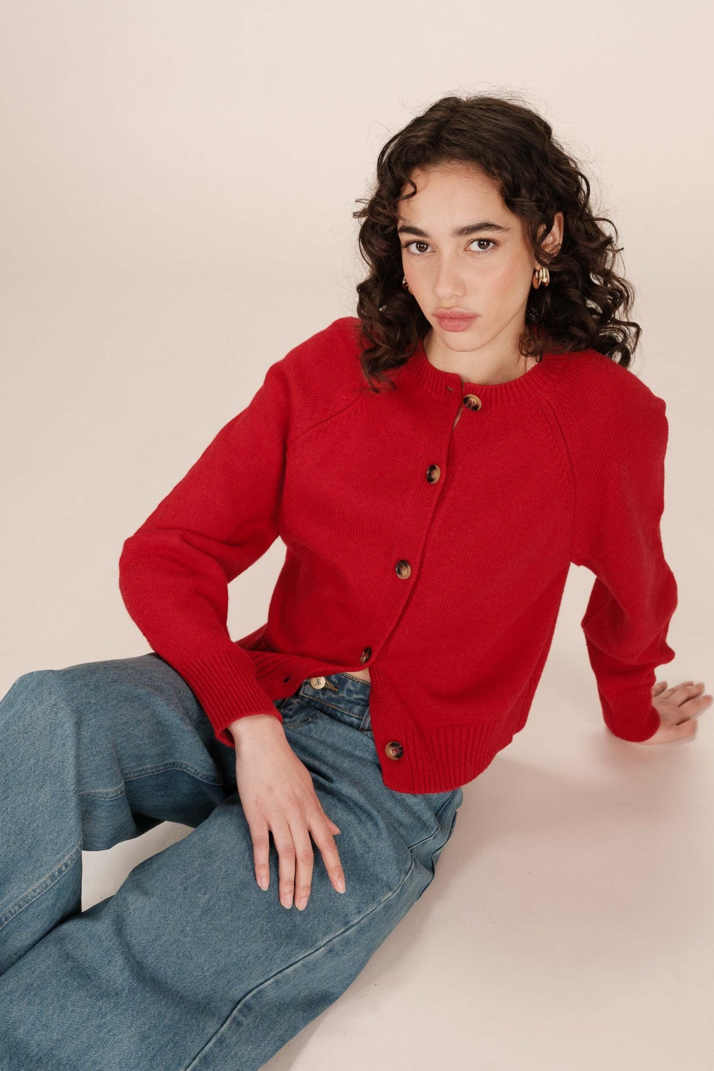 Vue diagonale du cardigan Sanders rouge - texture laine douce et coupe courte