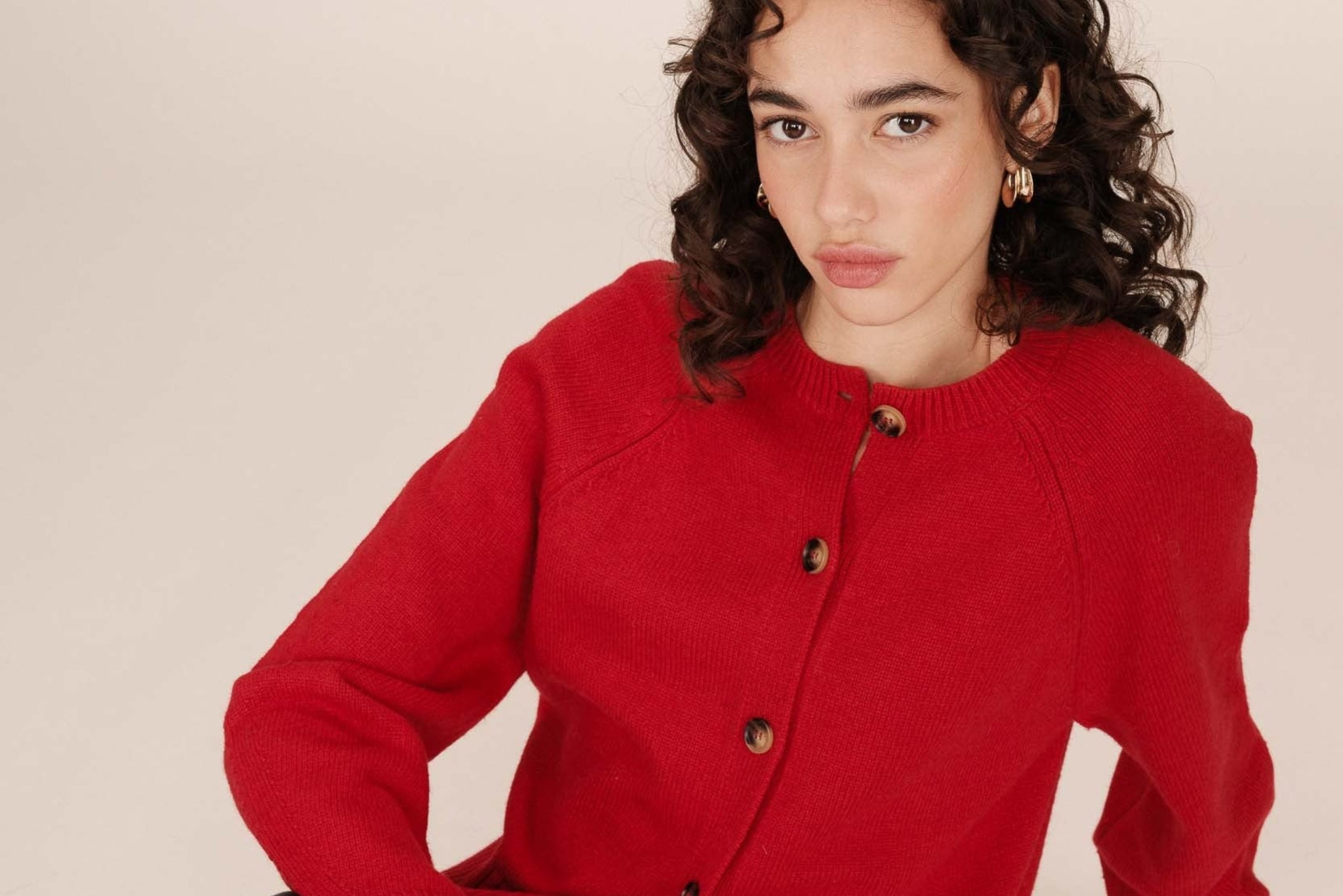 Vue diagonale du cardigan Sanders rouge - texture laine douce et coupe courte