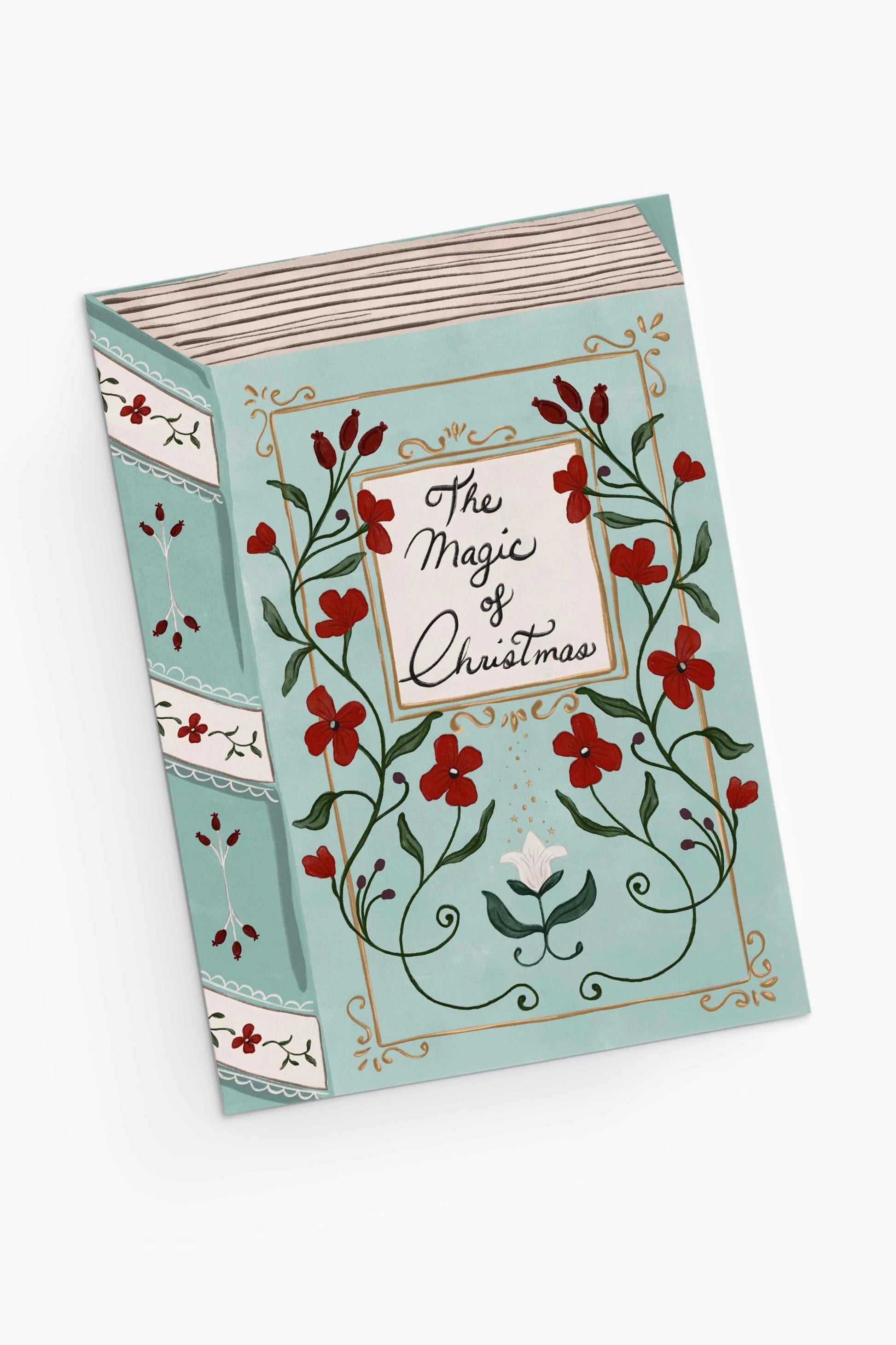 Carte La Magie de Noël vue en angle avec illustration florale rouge sur fond bleu, papier