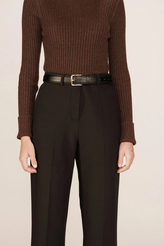 Ceinture noire portée sur pantalon, élégance moderne