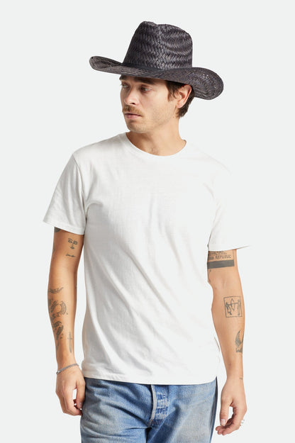 Homme portant le chapeau de paille noir avec t-shirt blanc – allure western moderne