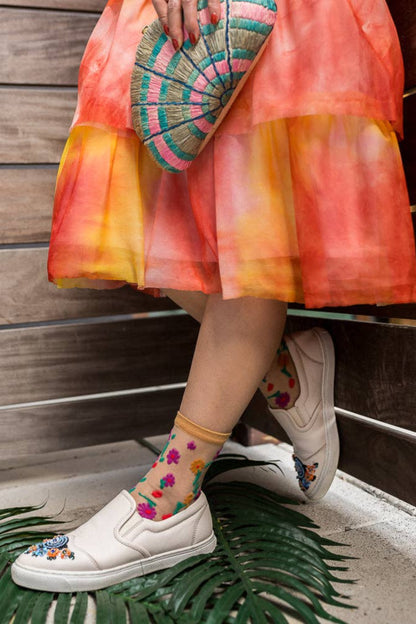 Chaussettes transparentes fleuries portées avec chaussures blanches