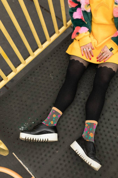 Chaussettes transparentes fleuries portées avec collants noirs