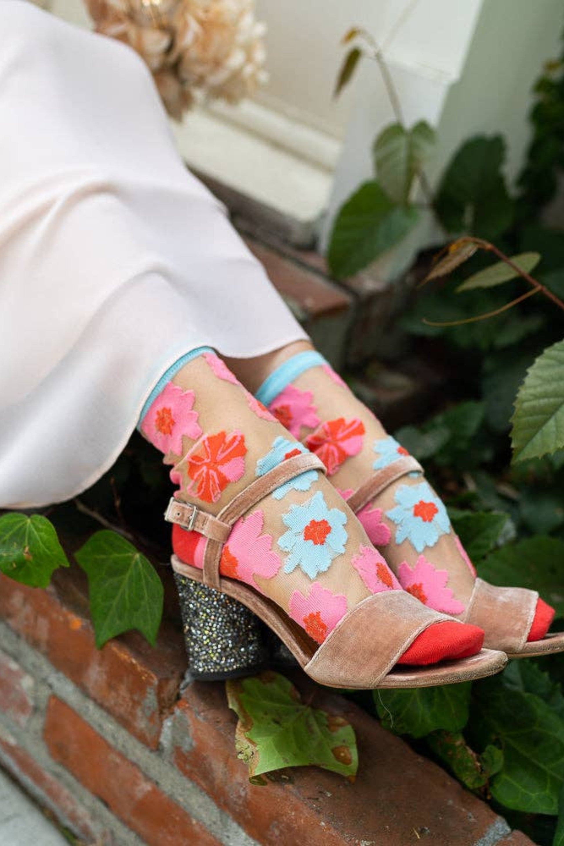 Chaussettes transparentes fleuries portées avec sandales roses