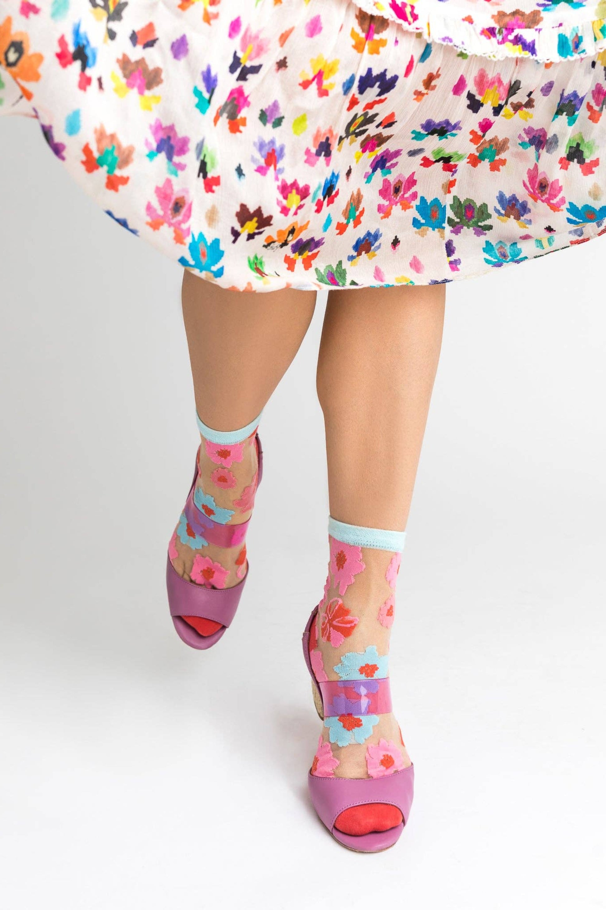 Chaussettes transparentes fleuries portées avec sandales à talons et une robe fleurie