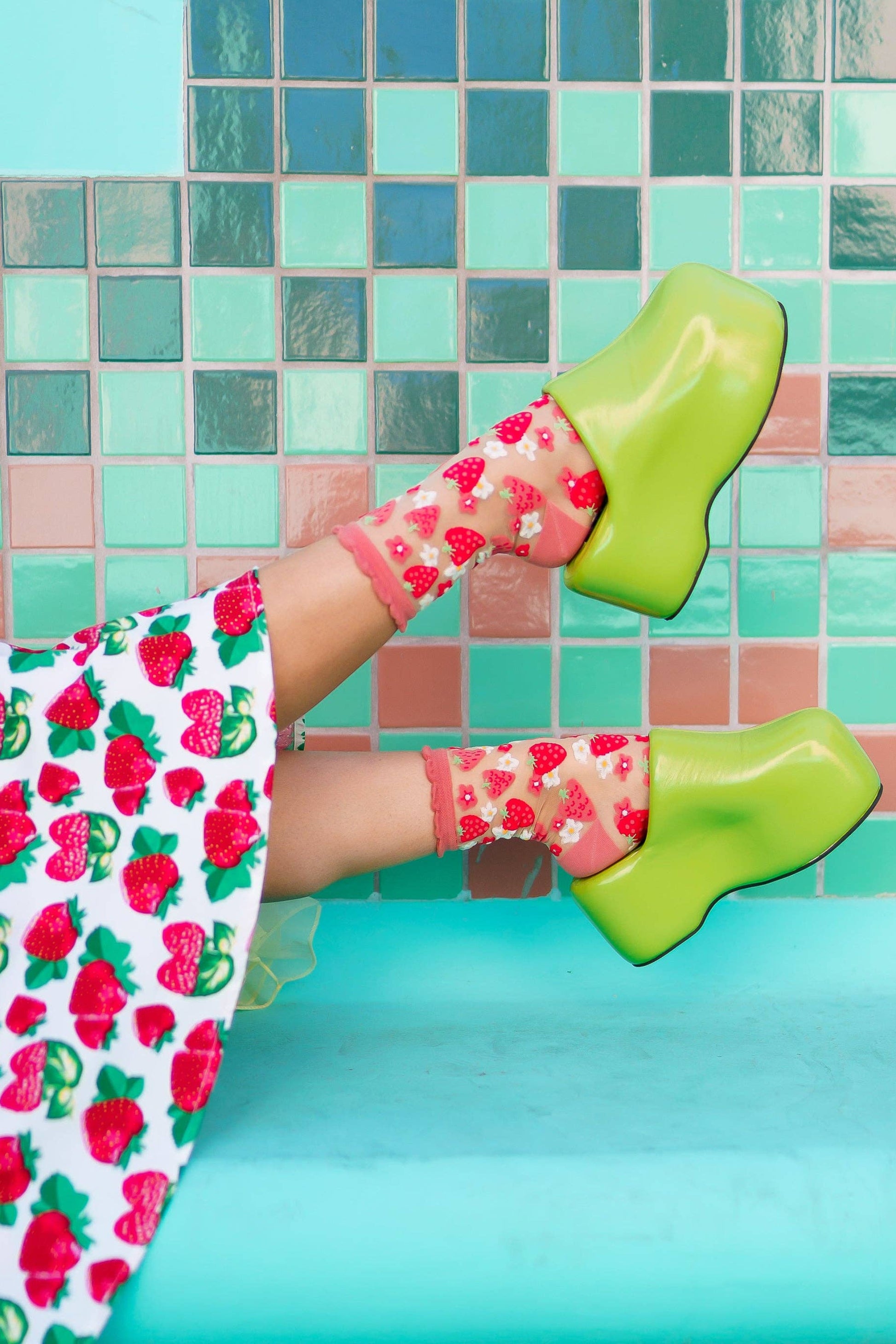 Chaussettes transparentes Strawberry Ruffle à motif fraises portées avec sabots verts