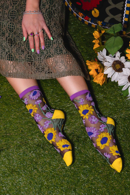 Chaussettes transparentes noires tournesols dans un look élégant avec robe et accessoires