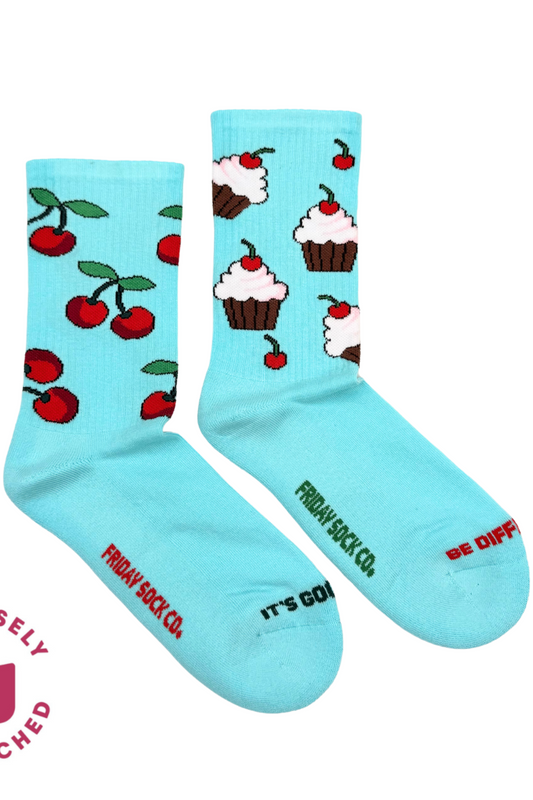 Paire de chaussettes dépareillées bleu pastel avec motifs cerises et cupcakes