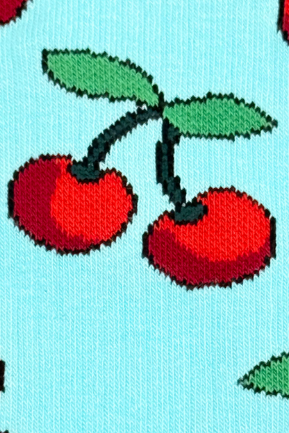 Détail du motif cerises rouges sur fond bleu pastel des chaussettes