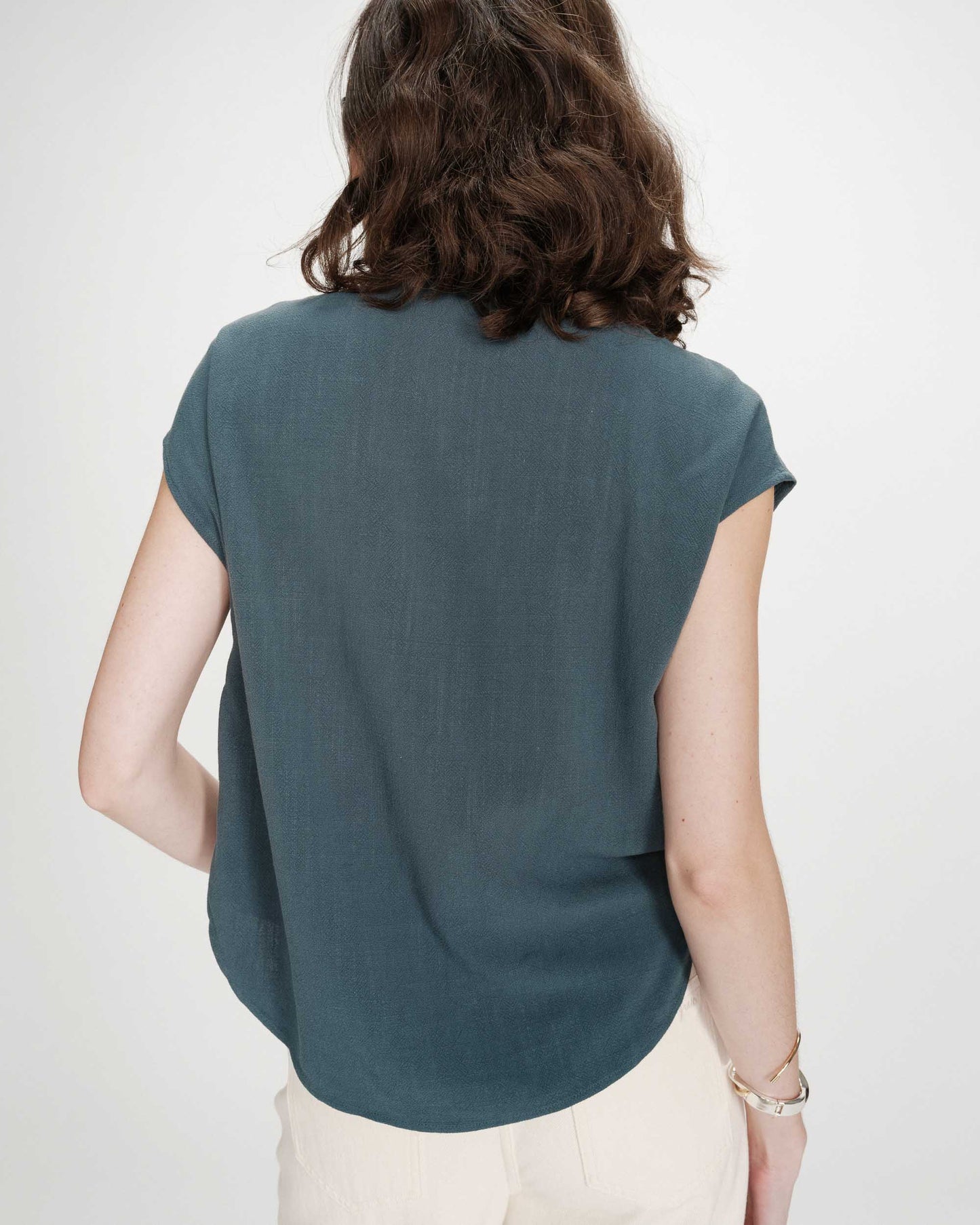 Chemise émeraude portée de dos avec coupe fluide