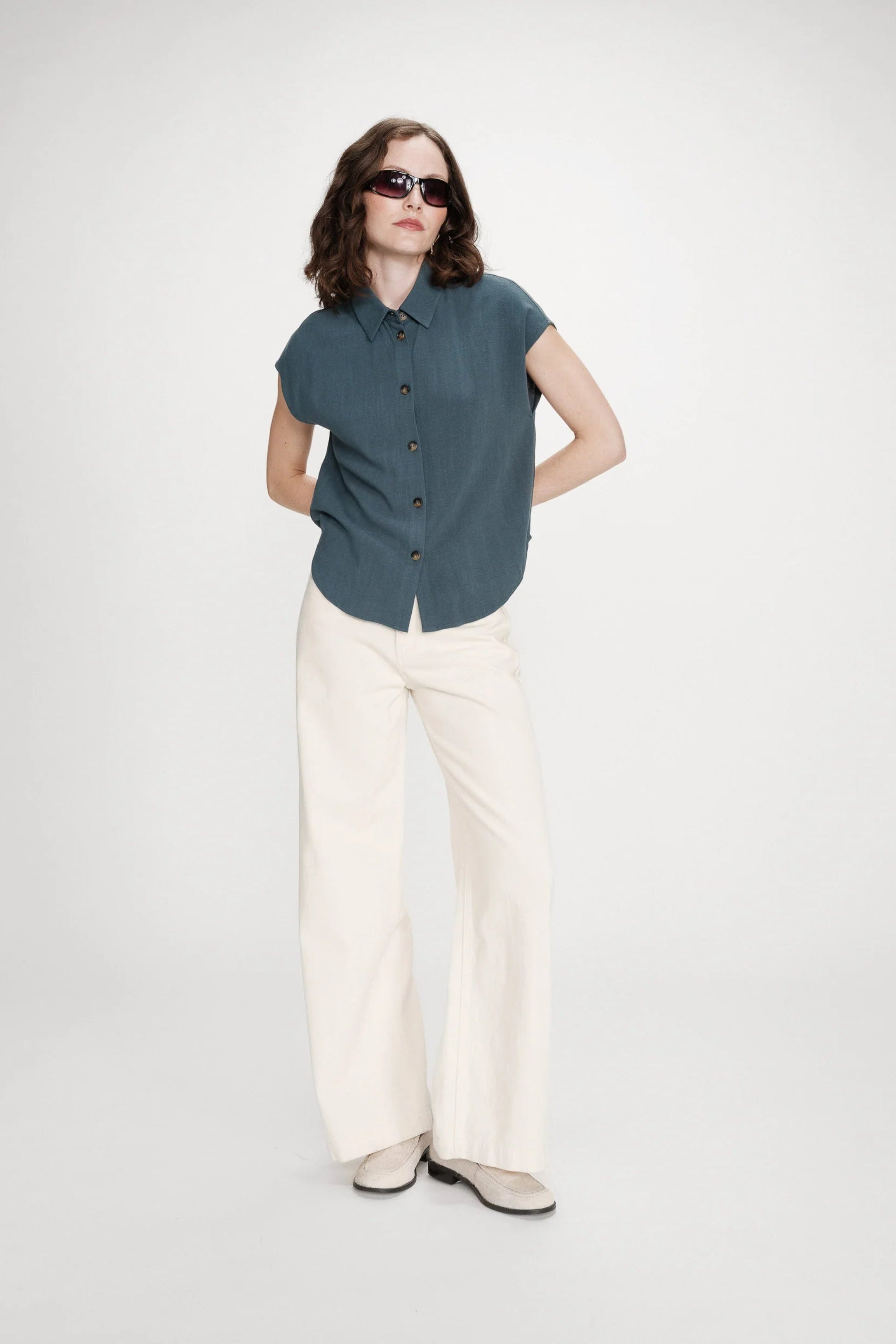 Chemise émeraude portée avec pantalon clair pour un look élégant et décontracté
