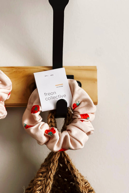 Chouchou en coton biologique motif fraises accroché au mur – accessoire cheveux artisanal