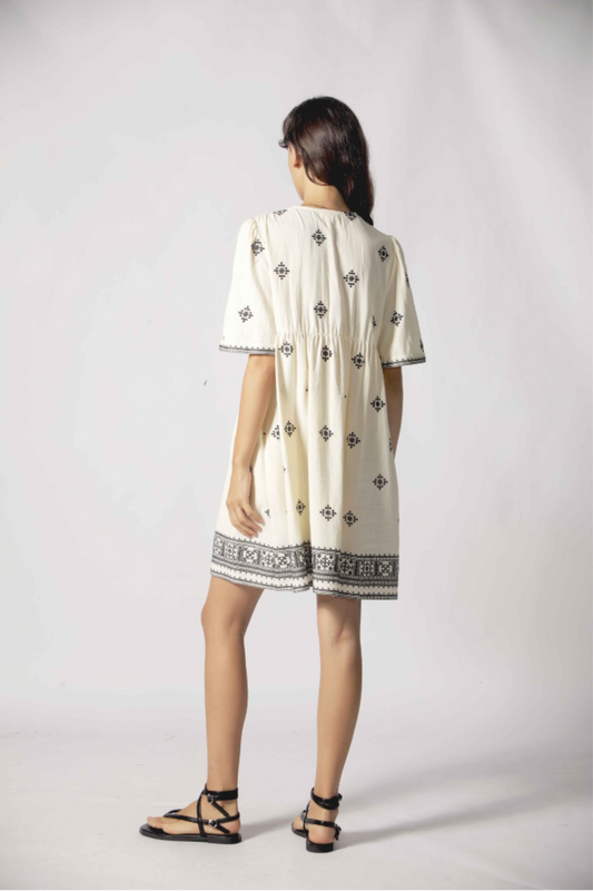 Robe courte Clelia blanc vue de dos avec coupe fluide, manches courtes et broderies noires.