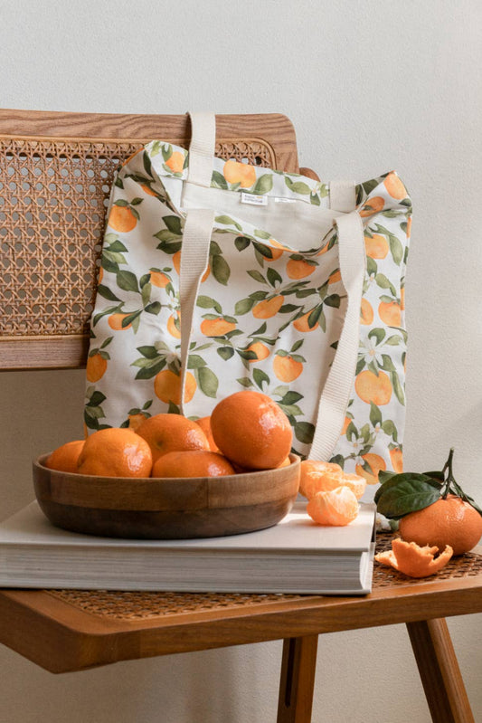 Sac fourre-tout motif oranges posé sur chaise en bois avec clémentines