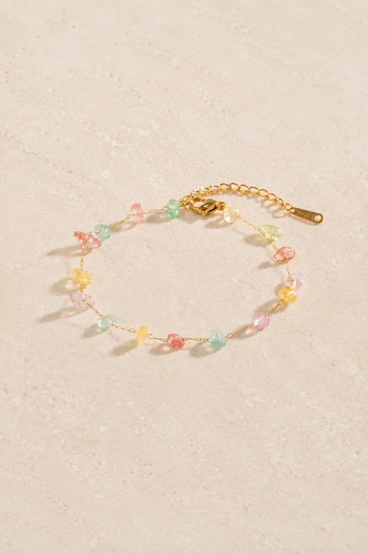 Bracelet Clochette Or avec chaîne dorée fine et petites pierres colorées pastel.
