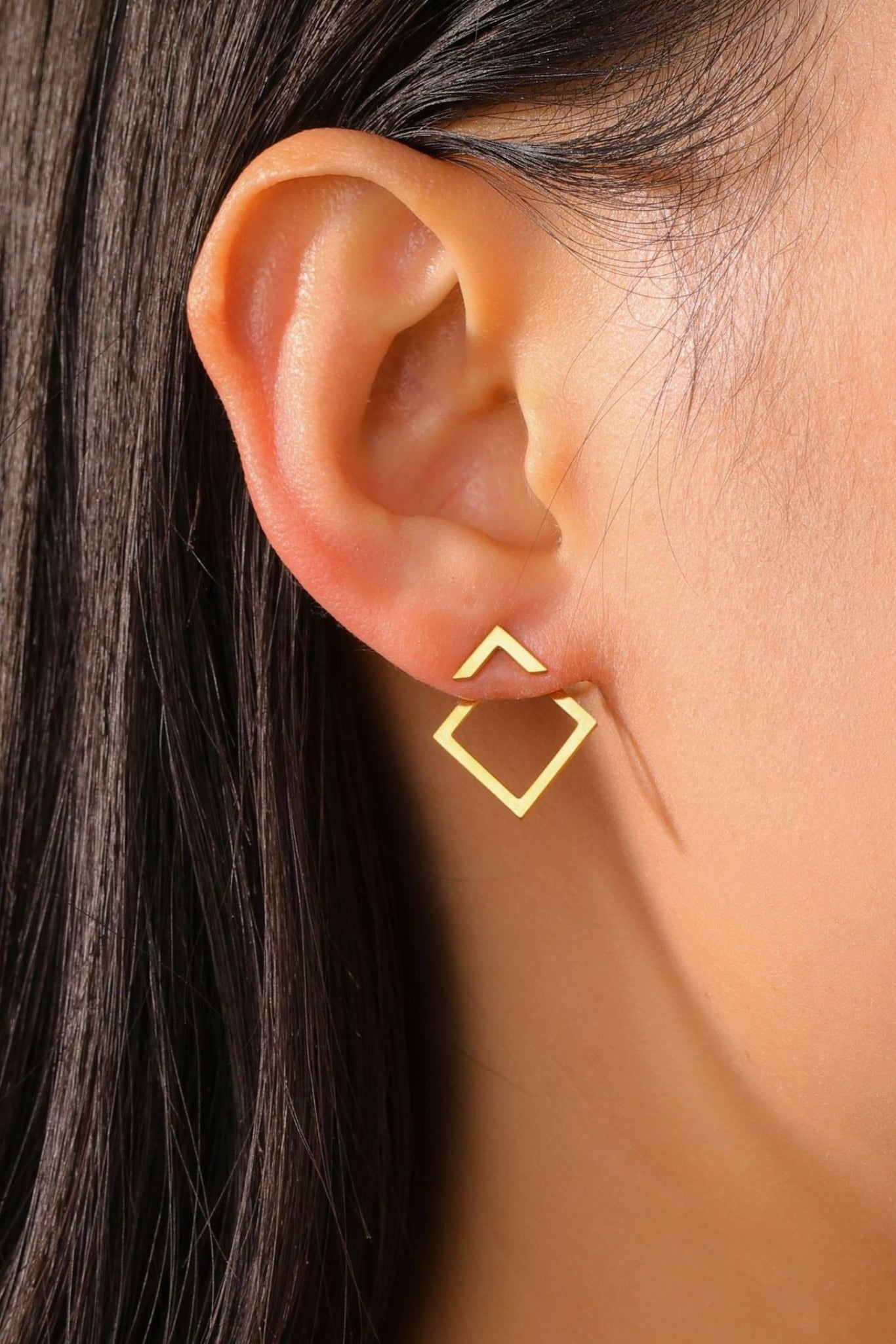 Clous d’oreilles Mona dorés portés sur l’oreille – design géométrique losange minimaliste