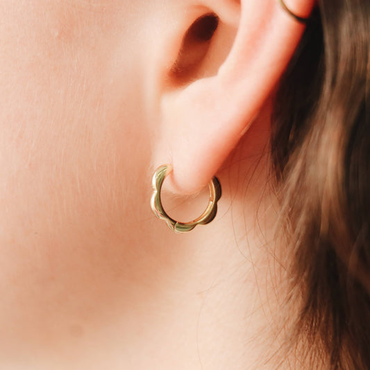 Créole Colio portée à l’oreille, forme ondulée plaquée or – Élégance et simplicité