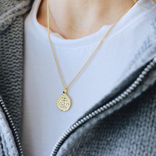Collier doré Cecio porté avec pendentif rond martelé en laiton plaqué or 18k