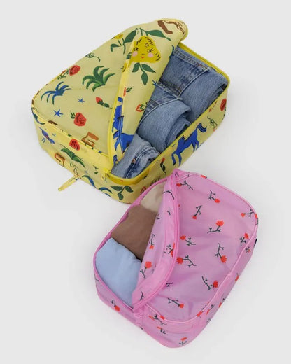 Pochettes de voyage Baggu ouvertes – vêtements rangés à l’intérieur, imprimés floraux et nature