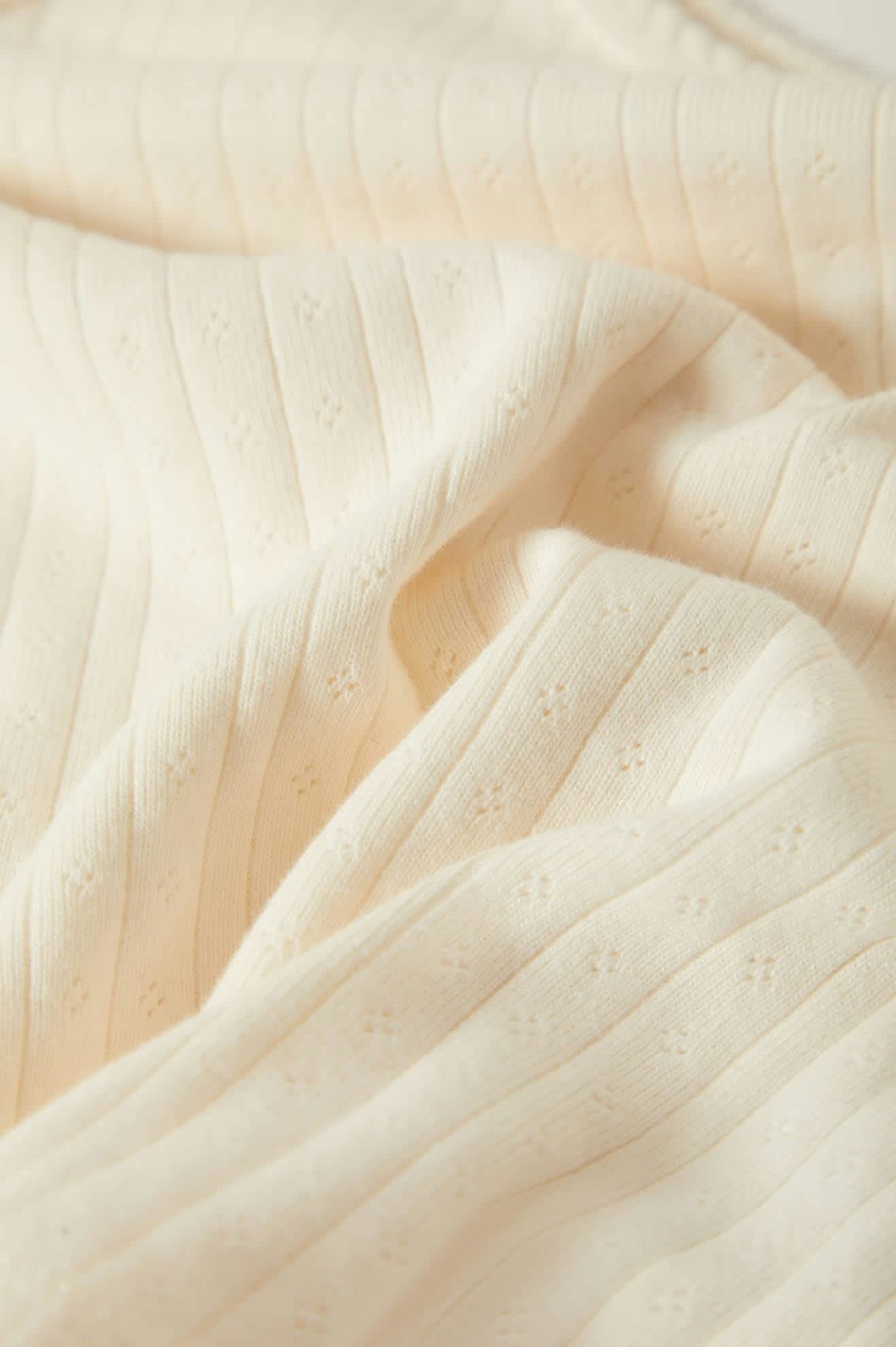 Gros plan sur la maille pointelle coton, texture respirante