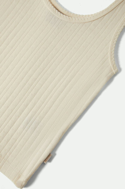 Détail bas du débardeur pointelle blanc avec étiquette latérale