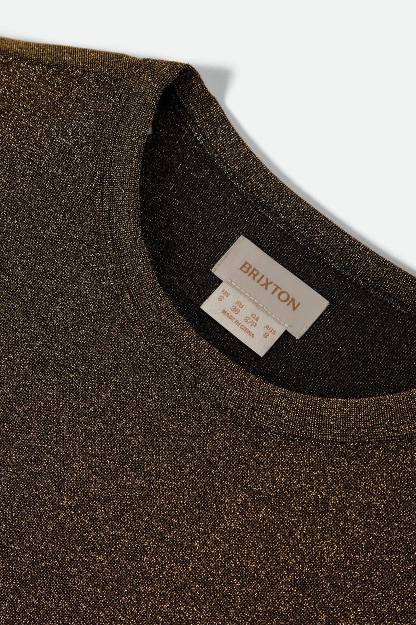 Détail du col rond du haut Donna doré, texture scintillante fine