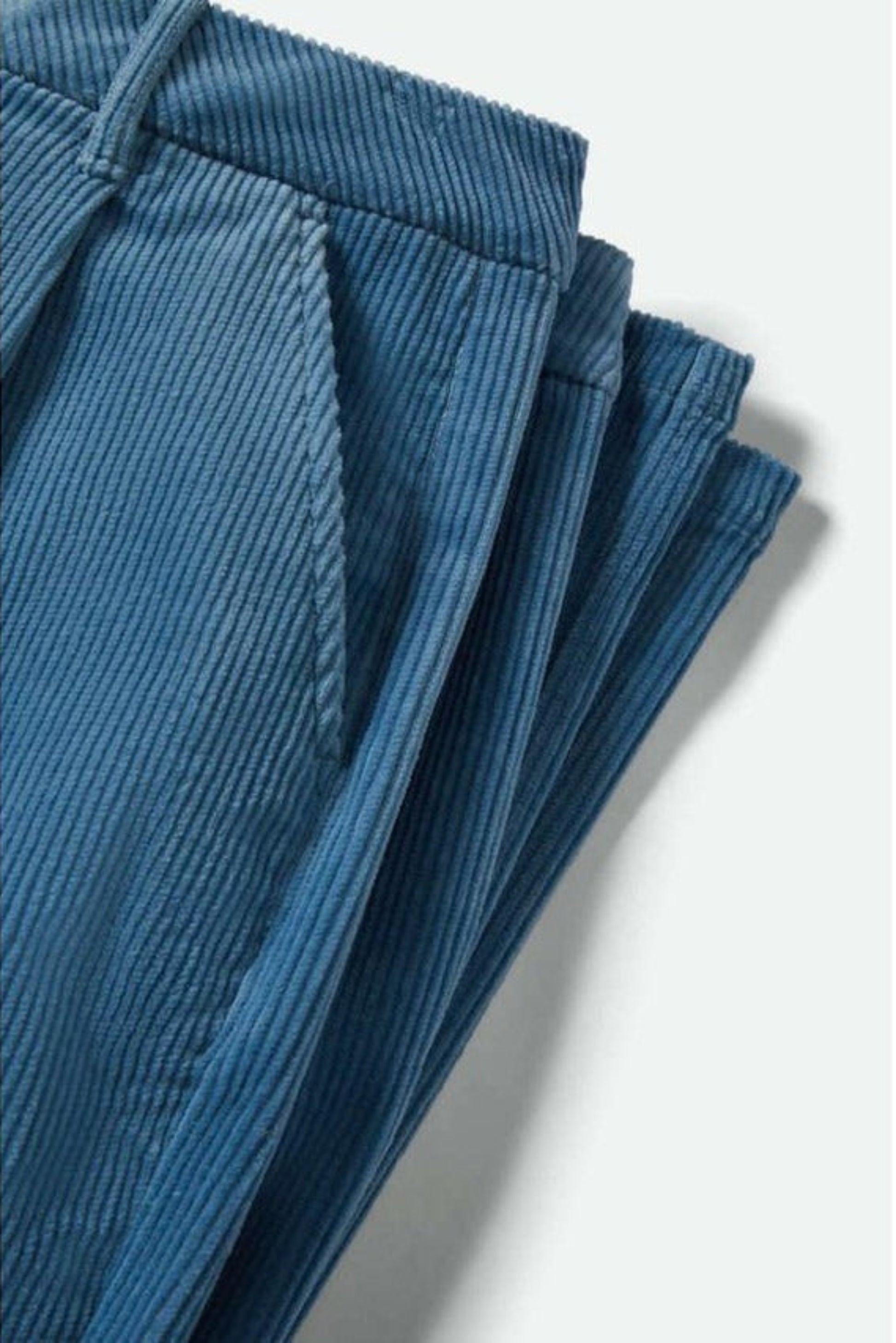 Gros plan sur les poches et la texture du velours côtelé bleu du pantalon Lola