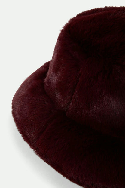 Gros plan sur la texture en fausse fourrure ultra-douce du bob bordeaux