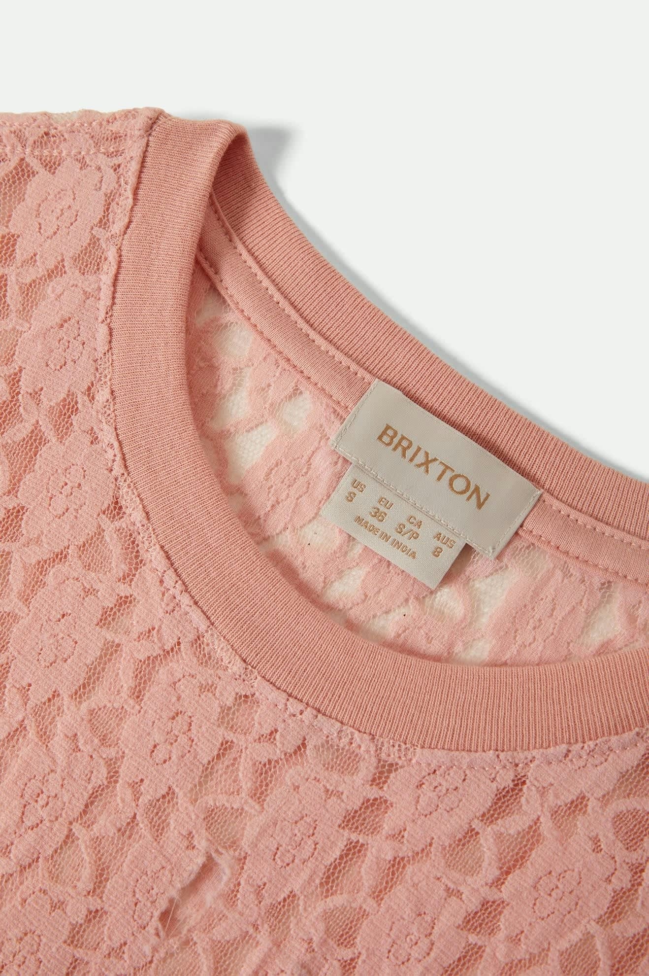 Gros plan sur l’encolure ronde du haut Dolly en dentelle rose – finition soignée