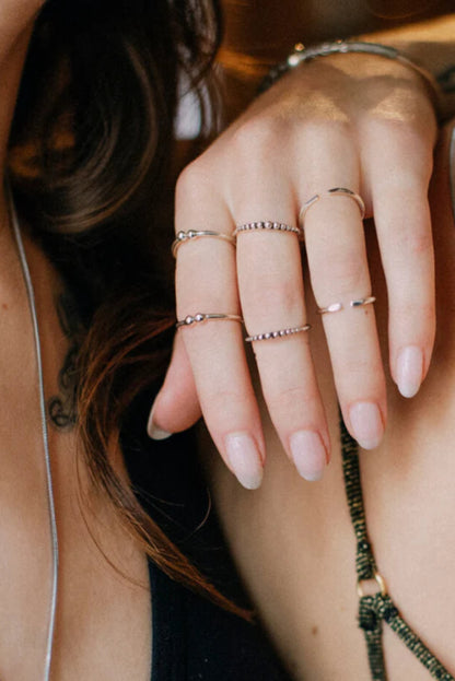 Bague Dots Argent portée avec d’autres bagues fines, détail perlé minimaliste en argent sterling 925.