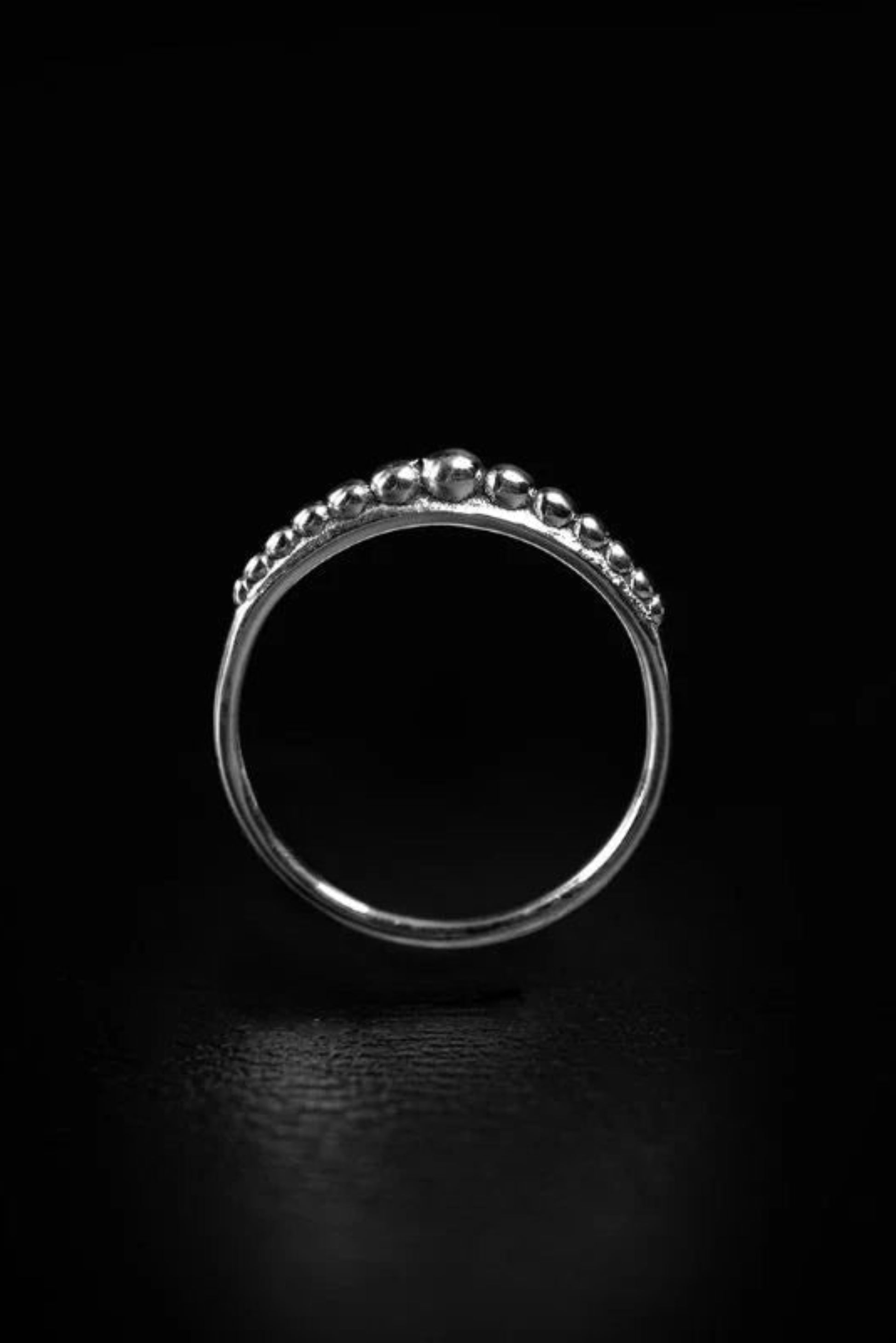 Bague Dots Argent vue de face sur fond noir, anneau fin avec détails perlés brillants.